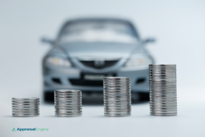 Blurred image of a silver car with four stacks of coins in increasing height in the foreground, symbolizing rising costs. The 'AppraisalEngine' logo is visible, indicating a focus on vehicle valuation.