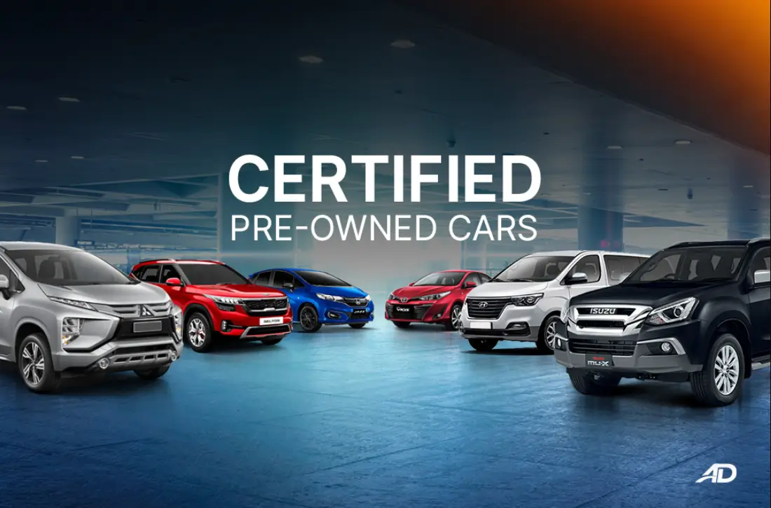 Certified Pre-Owned cars lined up in a modern indoor showroom, featuring various makes and models in different colors. The bold 'Certified Pre-Owned Cars' text highlights the dealership's selection of reliable, high-quality vehicles.