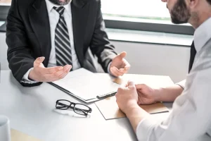Client and lawyer discussing insurance settlement strategy at a desk with document.