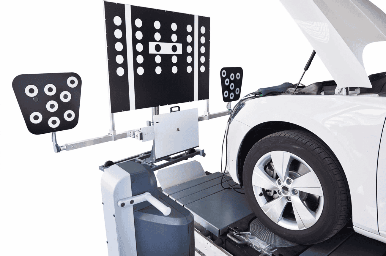 ADAS calibration equipment with target panels positioned in front of a white car during static sensor calibration in a repair shop