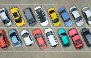 Aerial view of colorful cars parked in a lot, showing variety of vehicle colors that affect resale value and diminished value claims
