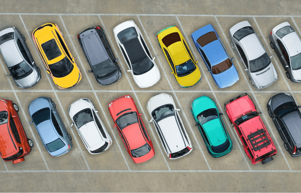 Aerial view of colorful cars parked in a lot, showing variety of vehicle colors that affect resale value and diminished value claims
