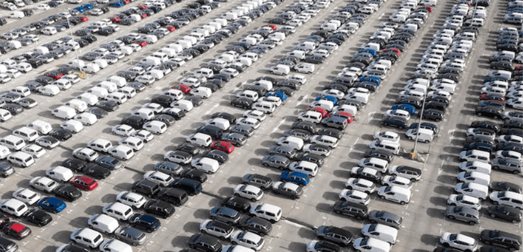 Aerial view of hundreds of parked cars showing the aging U.S. vehicle fleet affecting total loss value