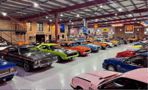 Rows of restored American muscle cars in a private collection warehouse, illustrating collector car diminished value
