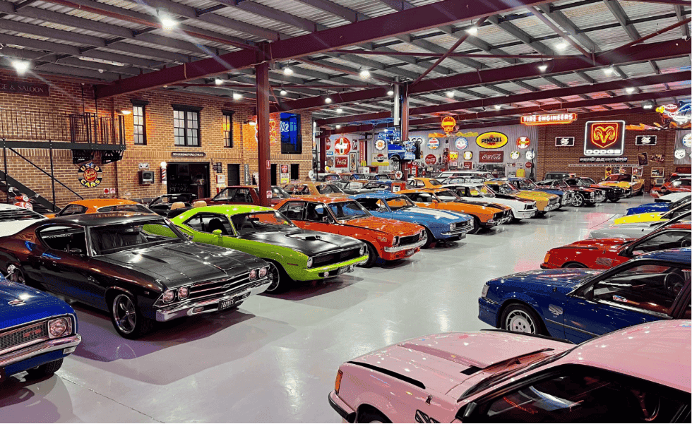 Rows of restored American muscle cars in a private collection warehouse, illustrating collector car diminished value