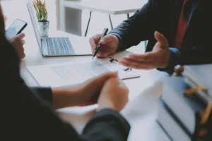 Close-up of an insurance agent reviewing claim documents with a client during a negotiation meeting