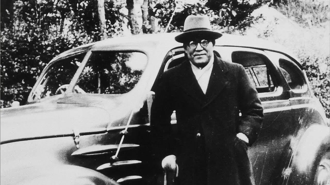 Kiichiro Toyoda, the visionary founder of Toyota Motor Corporation, standing proudly next to an early model car. His innovative spirit and dedication laid the foundation for Toyota's global success.