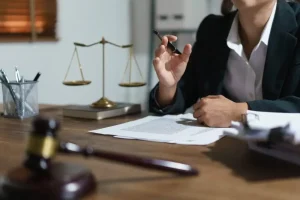 Lawyer at desk with justice scales, legal papers, and gavel discussing a case